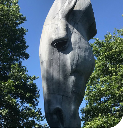 Horse statue in sun with shadows and blue sky